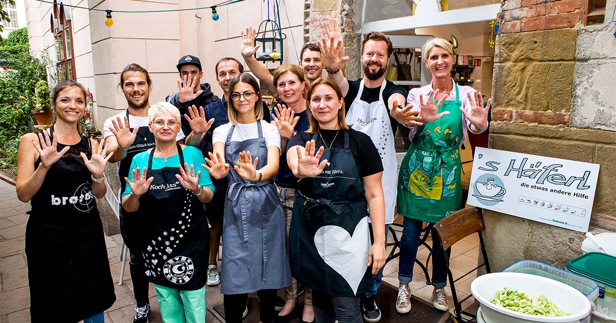 Eine Gruppe von Mitarbeiter:innen nach dem Corporate Volunteering Einsatz beim Kochen im "s'Häferl" in Wien. 